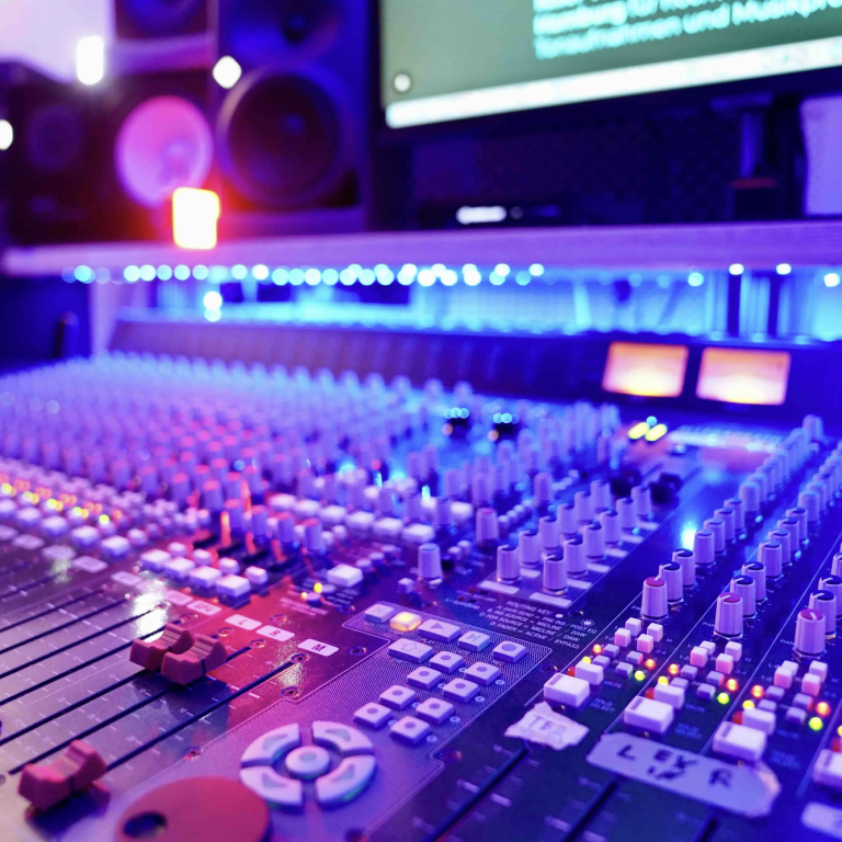 Mixing, Song Abmischen in Hamburg Tonstudio mit Mischpult und farbiger Beleuchtung im Hintergrund.