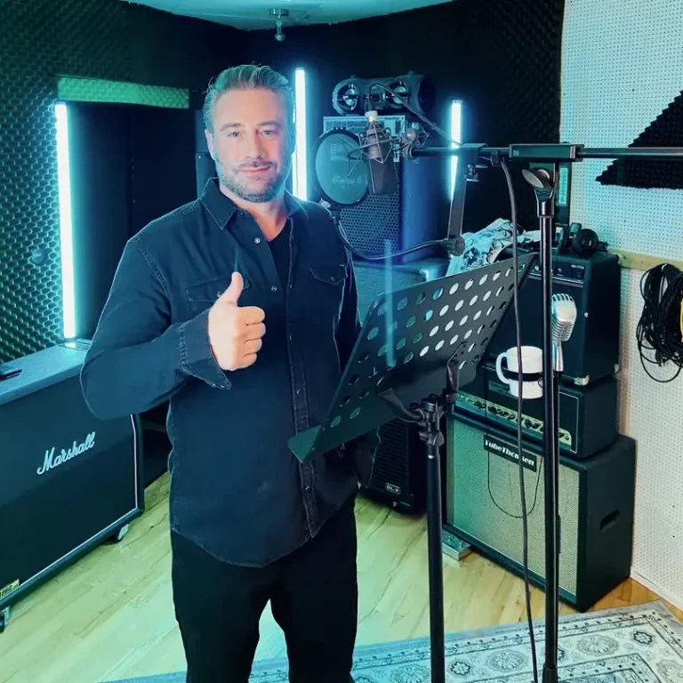 Recording, Tonaufnahmen in Hamburg Mann im Studio mit Daumen hoch, umgeben von Musikgeräten und LED-Lichtern.