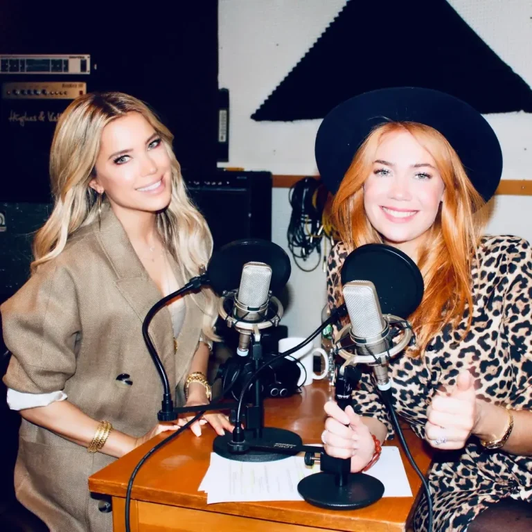 Podcast Produktion in Hamburg, Podcast aufnehmen Hamburg Zwei Frauen im Studio, eine lächelt und gibt einen Daumen hoch, Mikrofone vor ihnen.