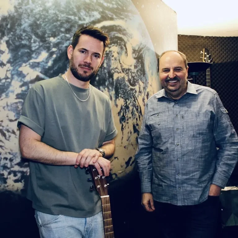 Interview Aufnahmen in Hamburg Zwei Männer stehen neben einer Erdkugel-Darstellung, einer hält eine Gitarre.