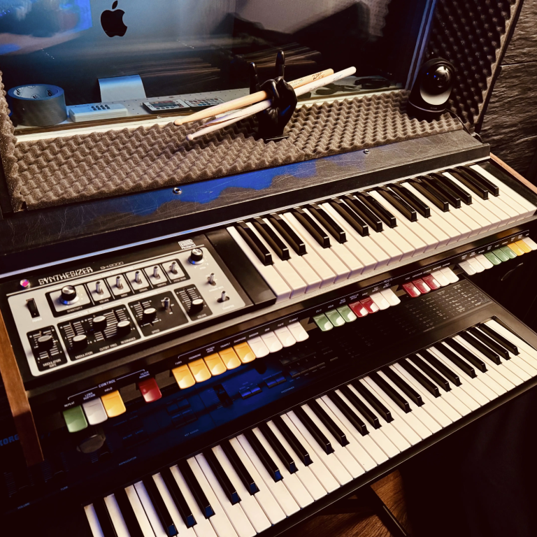 Sound Design in Hamburg Ein Musikinstrument mit Tasten, Reglern und Mikrofon, auf einem Tisch platziert.