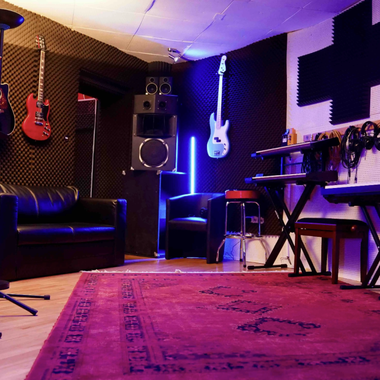 Foto- & Videodrehs in einem Tonstudio in Hamburg Musikstudio mit Gitarren, Keyboard, Mikrofon und Teppich in rot.