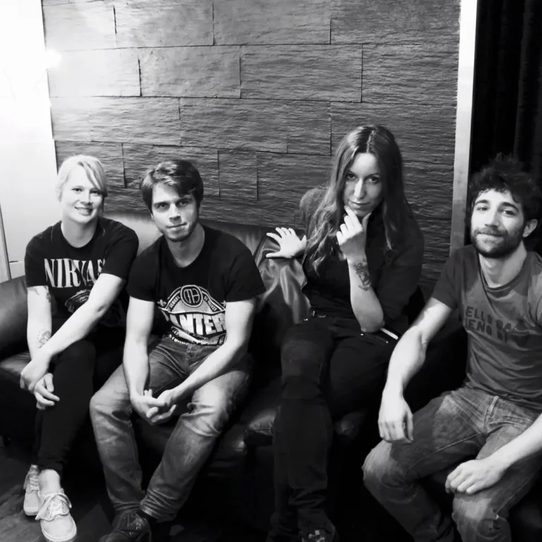 Bandrecording in Hamburg Vier Personen sitzen auf einer Couch, lächeln und posieren für die Kamera.