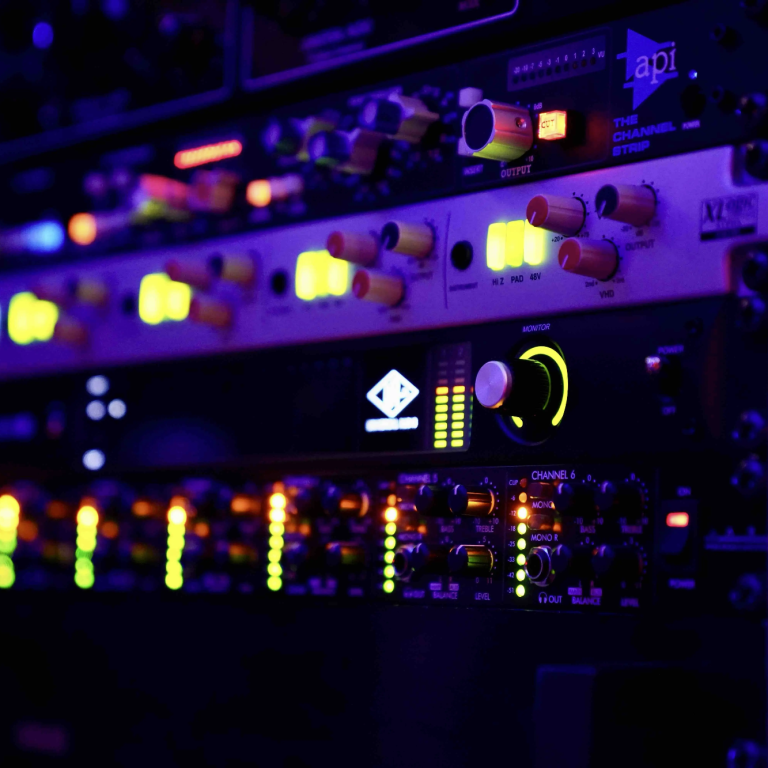 Mastering in Hamburg Anzeige von Musikproduktionsgeräten mit bunten LED-Leuchten und Reglern.